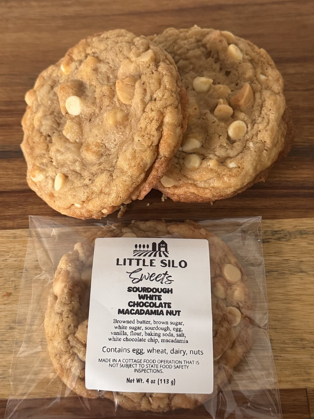 Sourdough white chocolate macadamia nut cookies, one wrapped with a Little Silo Sweets label