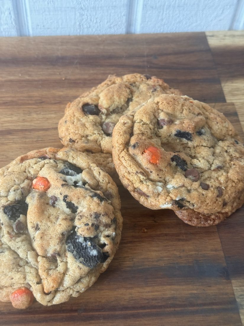 Sourdough monster cookies with chocolate chips, Oreo pieces and M&M's on a wooden board