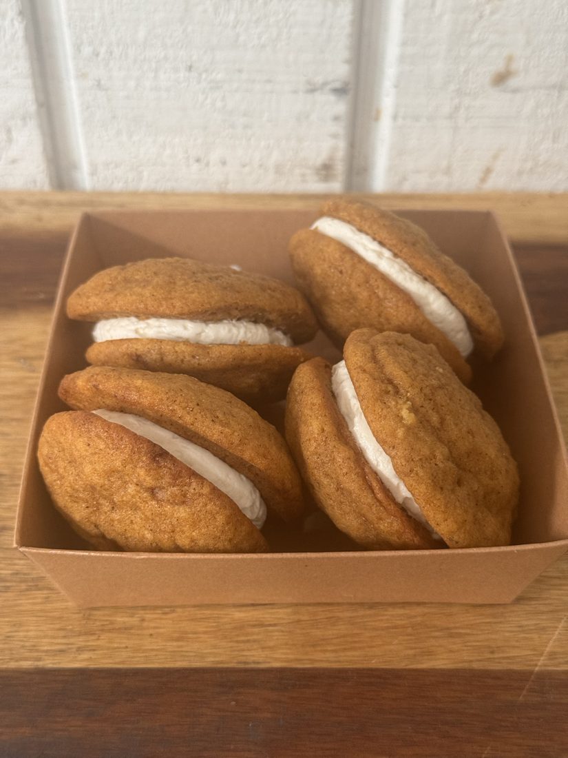 Four cream-filled Pumpkin Puffs sandwich cookies in a kraft box